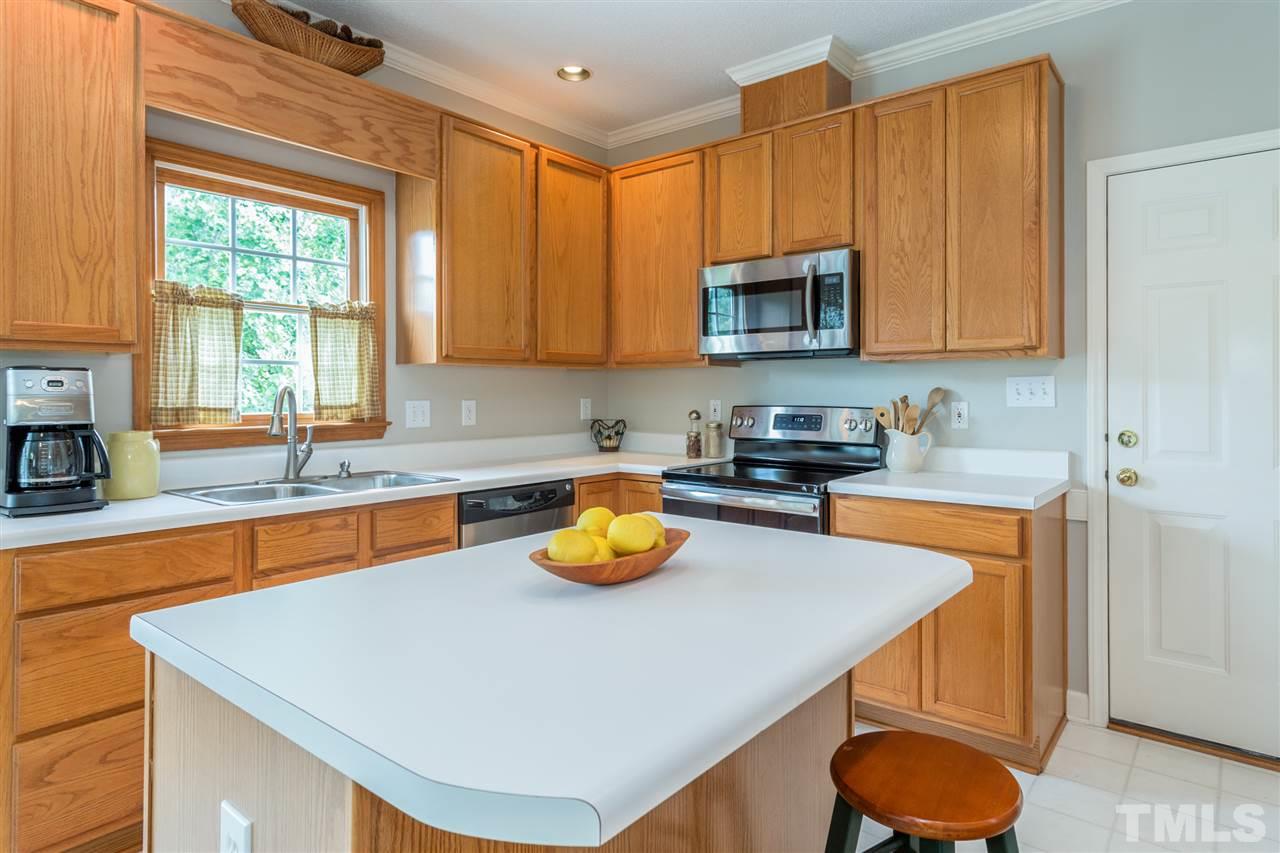 3225 Sandy Bluff Road Raleigh, NC 27616 - Photo 8 of 25 a kitchen with a sink a stove and a wooden cabinets