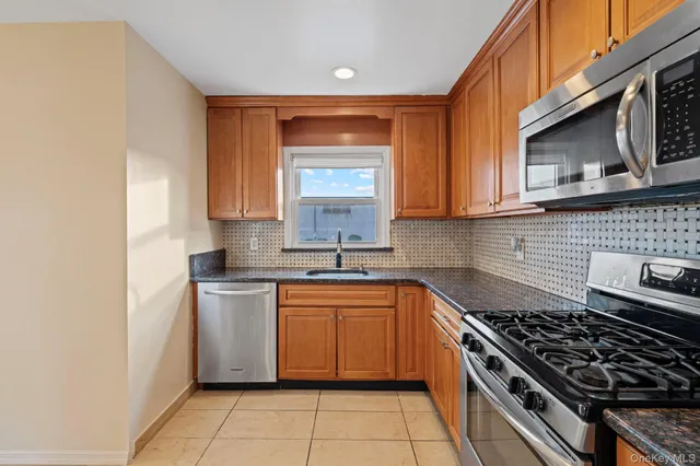 a kitchen with stainless steel appliances granite countertop a stove a sink and a microwave