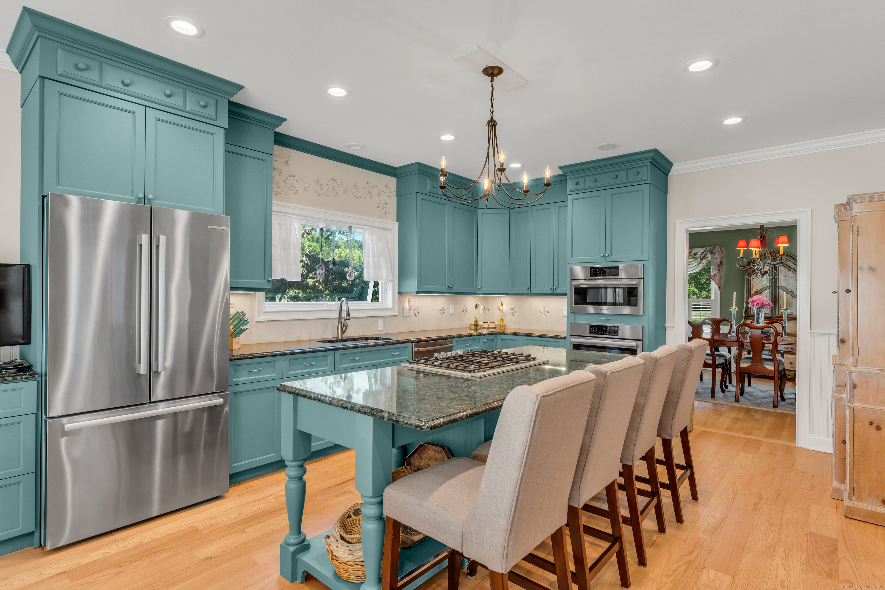 41 Allison Drive Madison, CT 06443 - Photo 11 of 40 a kitchen with stainless steel appliances granite countertop a kitchen island a table and chairs a refrigerator with wooden floor