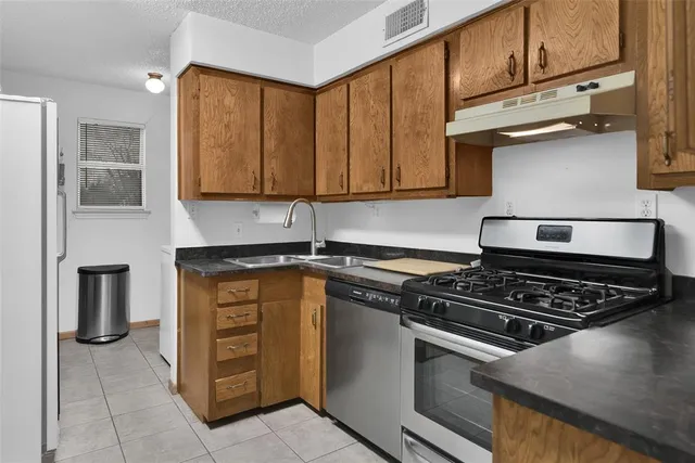 a kitchen with granite countertop a stove and a sink