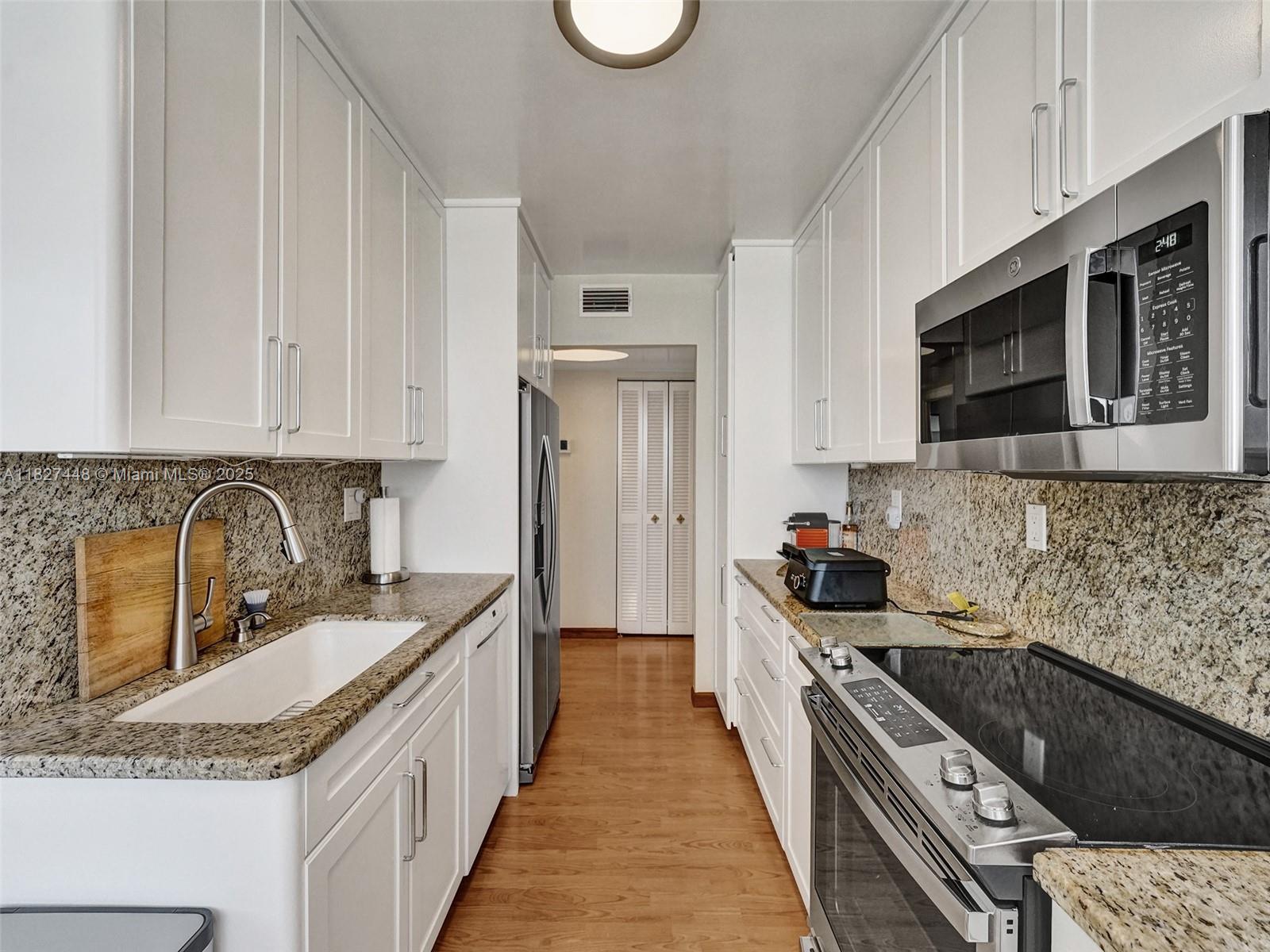 1833 South Ocean Drive, Unit 1702 Hallandale Beach, FL 33009 - Photo 22 of 80 a kitchen with stainless steel appliances granite countertop a sink stove and refrigerator