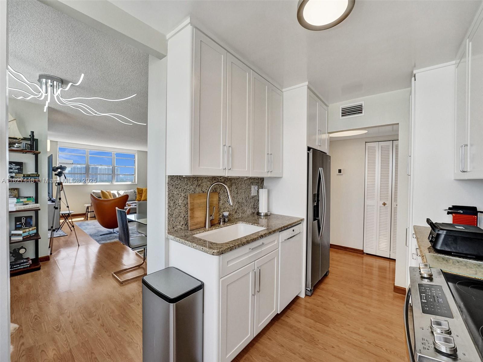 1833 South Ocean Drive, Unit 1702 Hallandale Beach, FL 33009 - Photo 23 of 80 a kitchen that has a lot of cabinets a sink and appliances in it