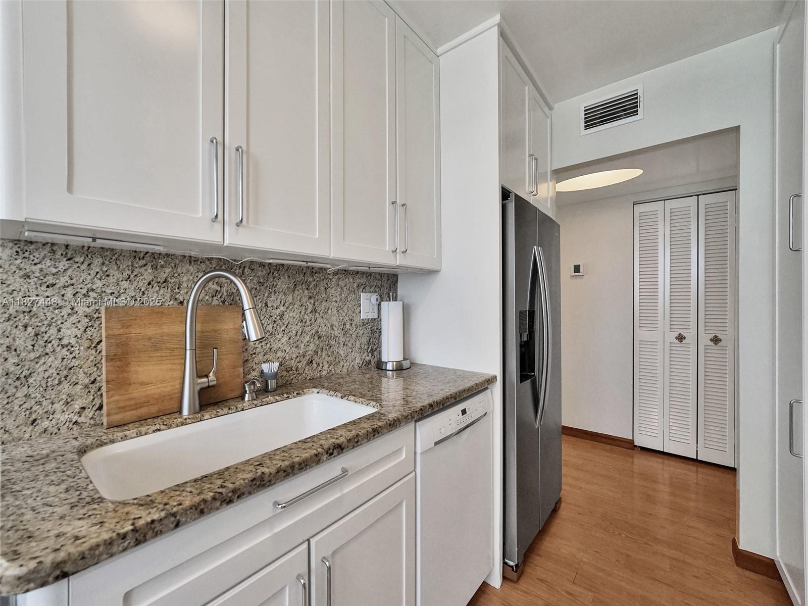 1833 South Ocean Drive, Unit 1702 Hallandale Beach, FL 33009 - Photo 24 of 80 a kitchen with granite countertop white cabinets and sink