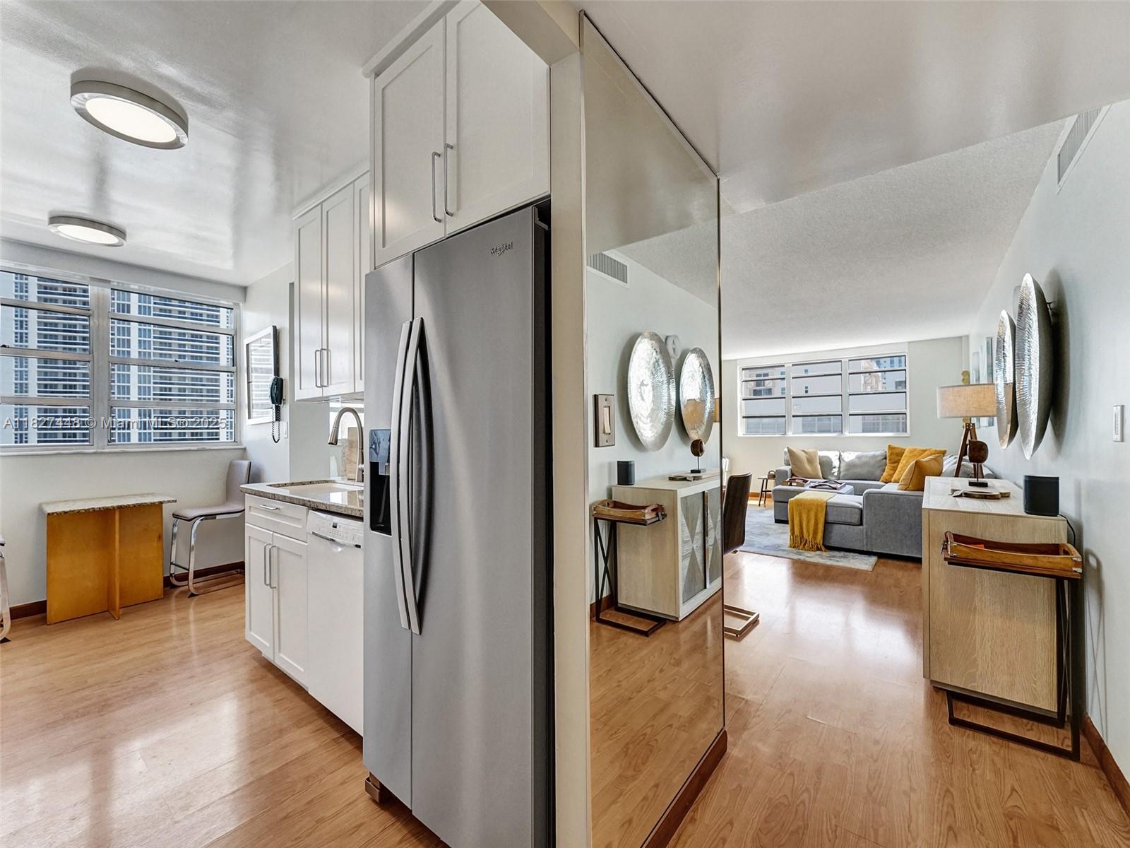 1833 South Ocean Drive, Unit 1702 Hallandale Beach, FL 33009 - Photo 3 of 80 a kitchen with stainless steel appliances a refrigerator a stove top oven a chimney wooden floor and cabinets