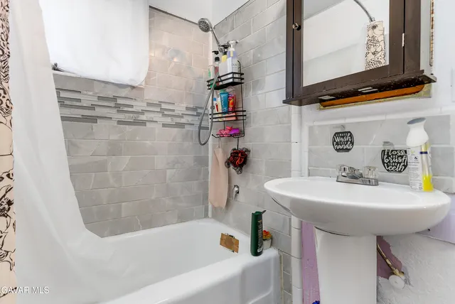 a bathroom with a sink a mirror and a bathtub
