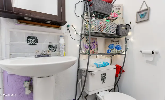 a bathroom with a sink mirror vanity and toilet