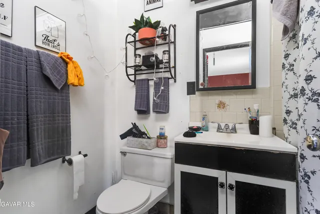 a bathroom with a sink vanity and toilet