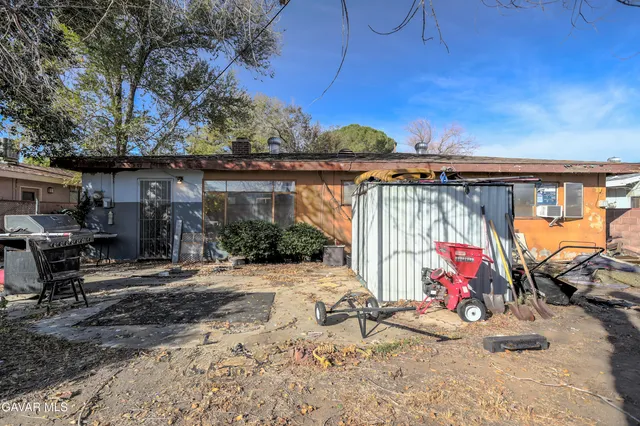 a view of the patio with a table and chairs under an umbrella