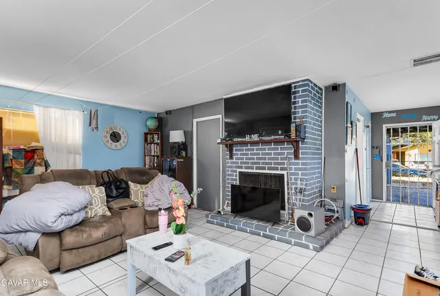a living room with furniture a flat screen tv and a fireplace