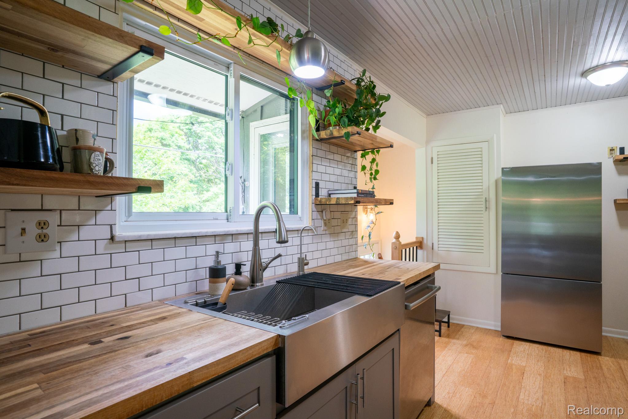 7333 Toma Road Dexter, MI 48130 - Photo 22 of 45 Kitchen featuring wood-finish countertops, subway tile backsplash, and a stainless steel farmhouse sink with an industrial faucet