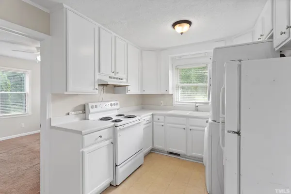 a kitchen with a sink cabinets appliances and a window