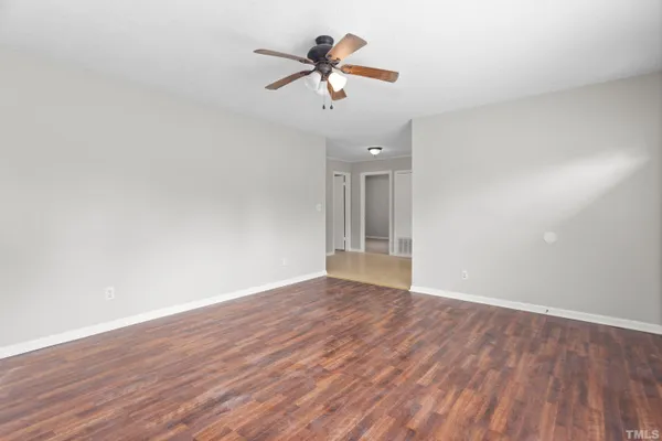 a view of room with wooden floor and ceiling fan