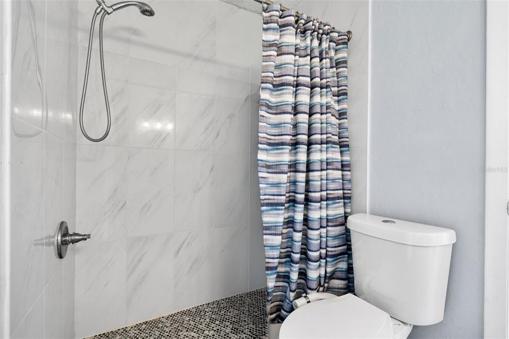128 Euclid Avenue Seffner, FL 33584 - Photo 19 of 38 a white toilet sitting next to a shower curtain