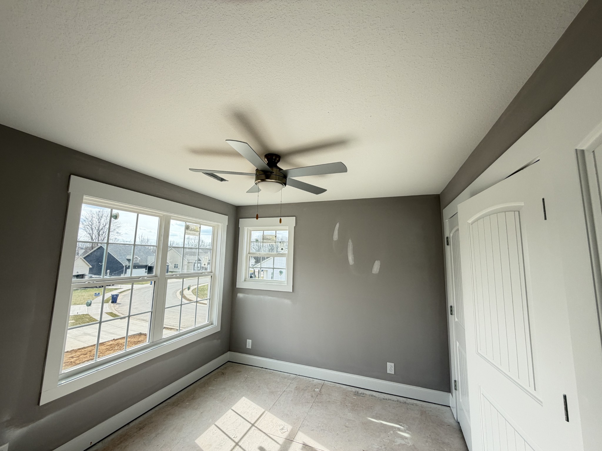 124 Hummingbird Way Clarksville, TN 37043 - Photo 11 of 12 en empty room with windows and chandelier fan