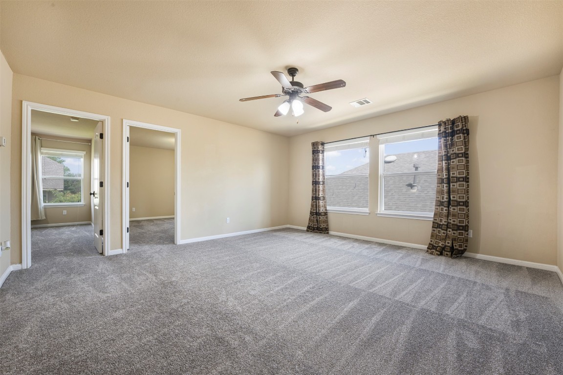 1812 Hidden Springs Path Round Rock, TX 78665 - Photo 25 of 39 an empty room with chandelier fan and windows