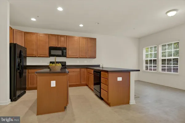 a kitchen with stainless steel appliances granite countertop a refrigerator a sink a stove a microwave and island