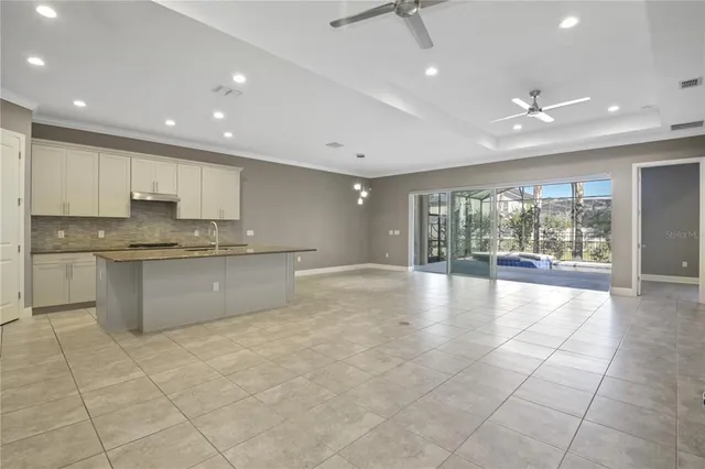 a large kitchen with stainless steel appliances granite countertop a large counter top and a stove top oven with wooden floor