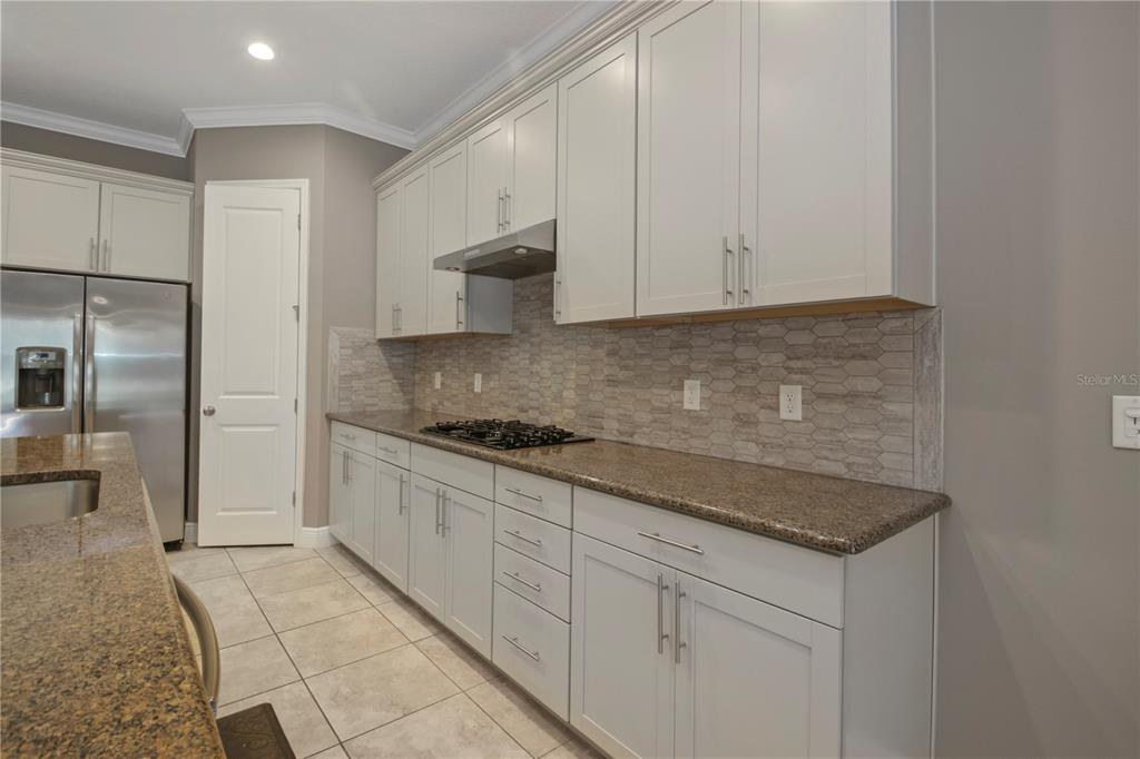 1427 Lake Florence Way Winter Park, FL 32792 - Photo 7 of 32 a kitchen with granite countertop white cabinets and stainless steel appliances