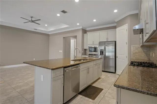 a kitchen with stainless steel appliances granite countertop a sink and a refrigerator