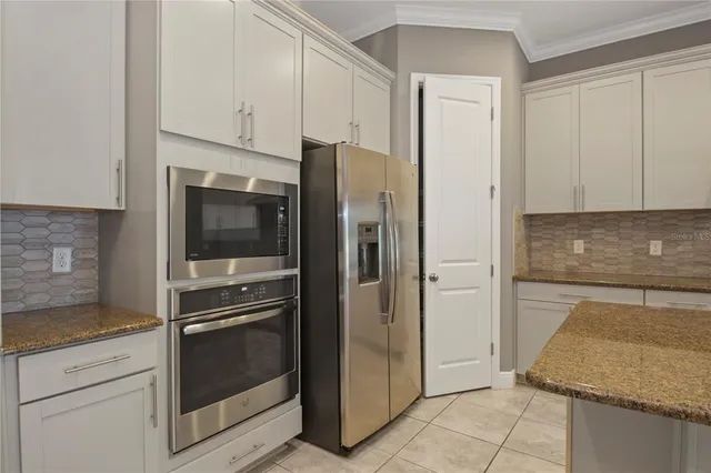 a kitchen with stainless steel appliances granite countertop a refrigerator and a stove
