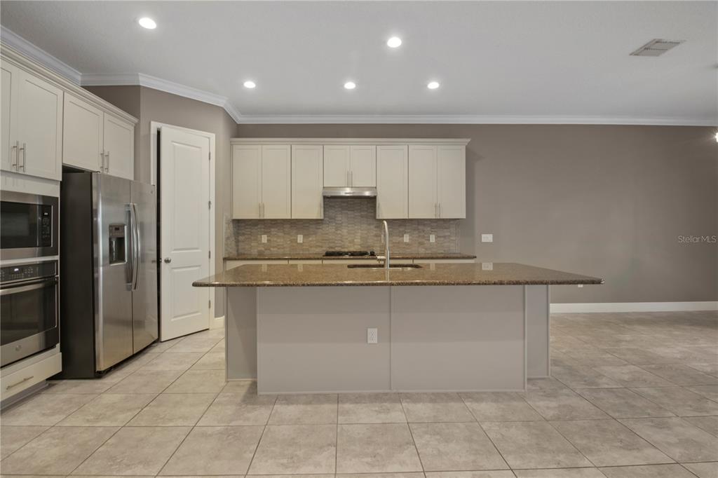 1427 Lake Florence Way Winter Park, FL 32792 - Photo 10 of 32 a large kitchen with stainless steel appliances granite countertop a stove a sink and a refrigerator