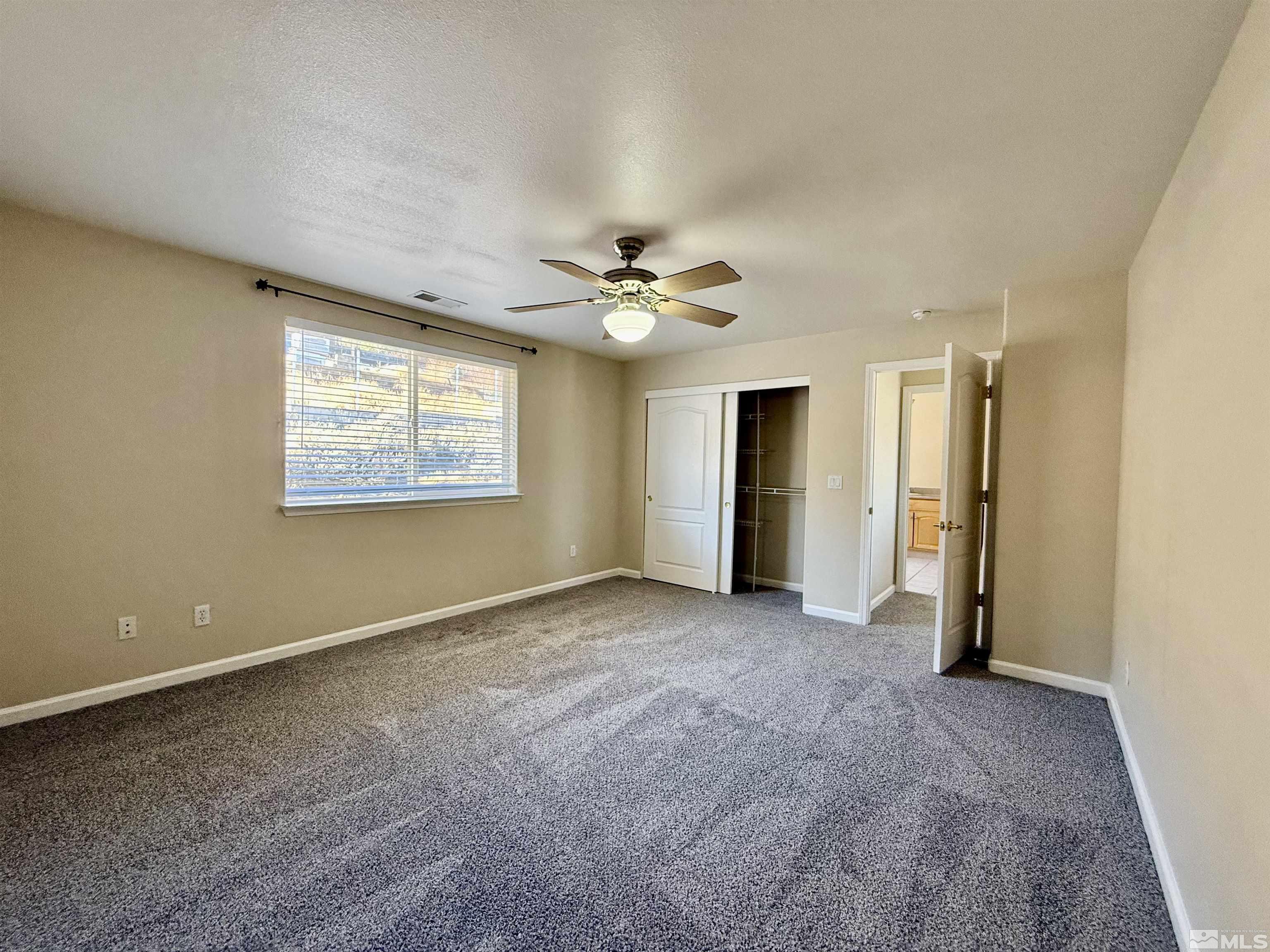 1090 Spring Drive Carson City, NV 89703 - Photo 18 of 31 an empty room with a ceiling fan and a window