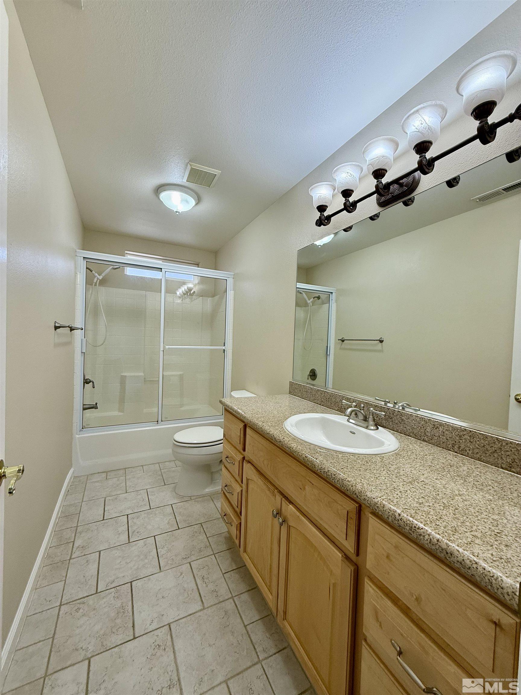1090 Spring Drive Carson City, NV 89703 - Photo 19 of 31 a spacious bathroom with a granite countertop sink a toilet a mirror and shower
