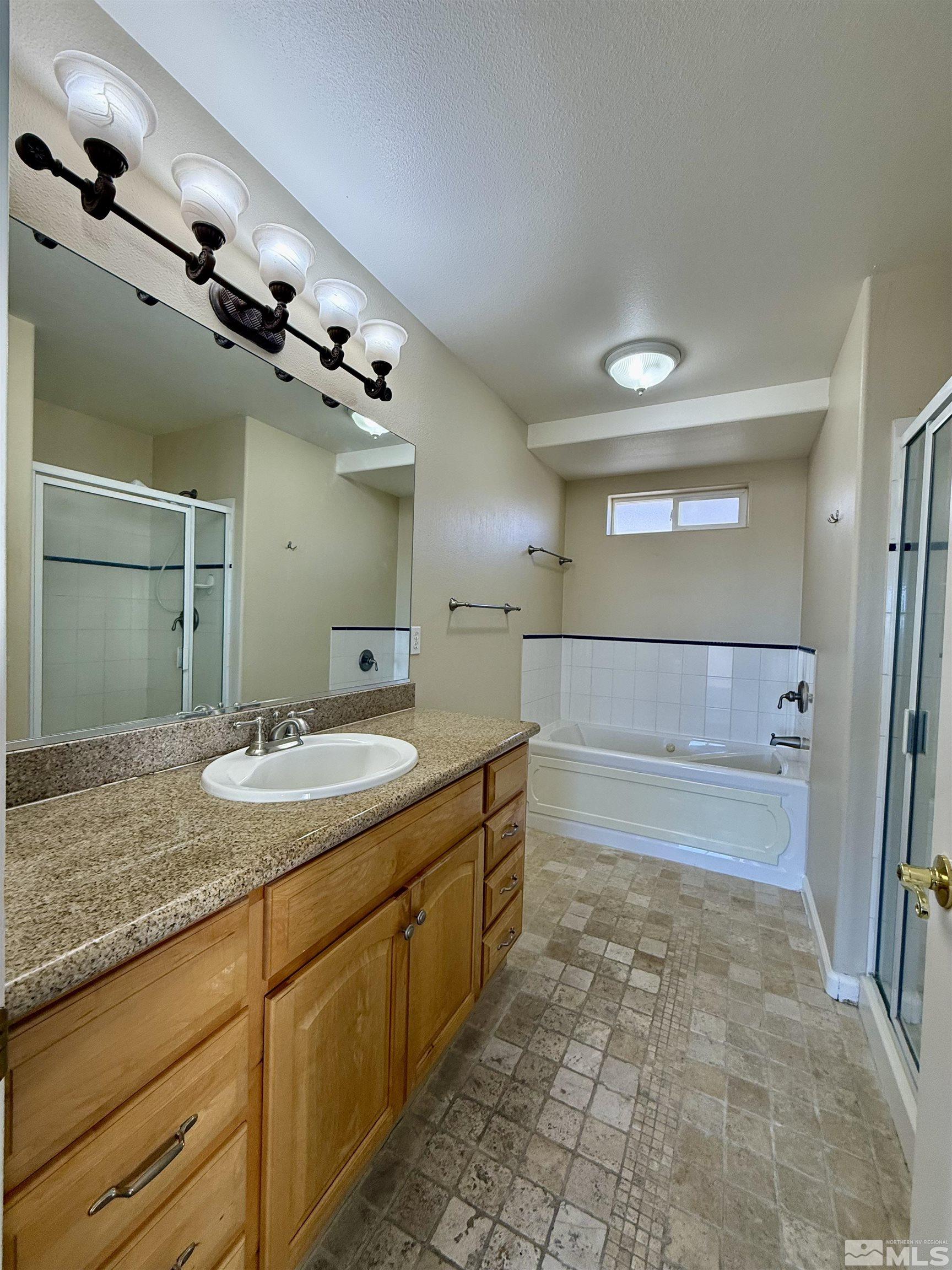 1090 Spring Drive Carson City, NV 89703 - Photo 26 of 31 a bathroom with a granite countertop sink a mirror and shower
