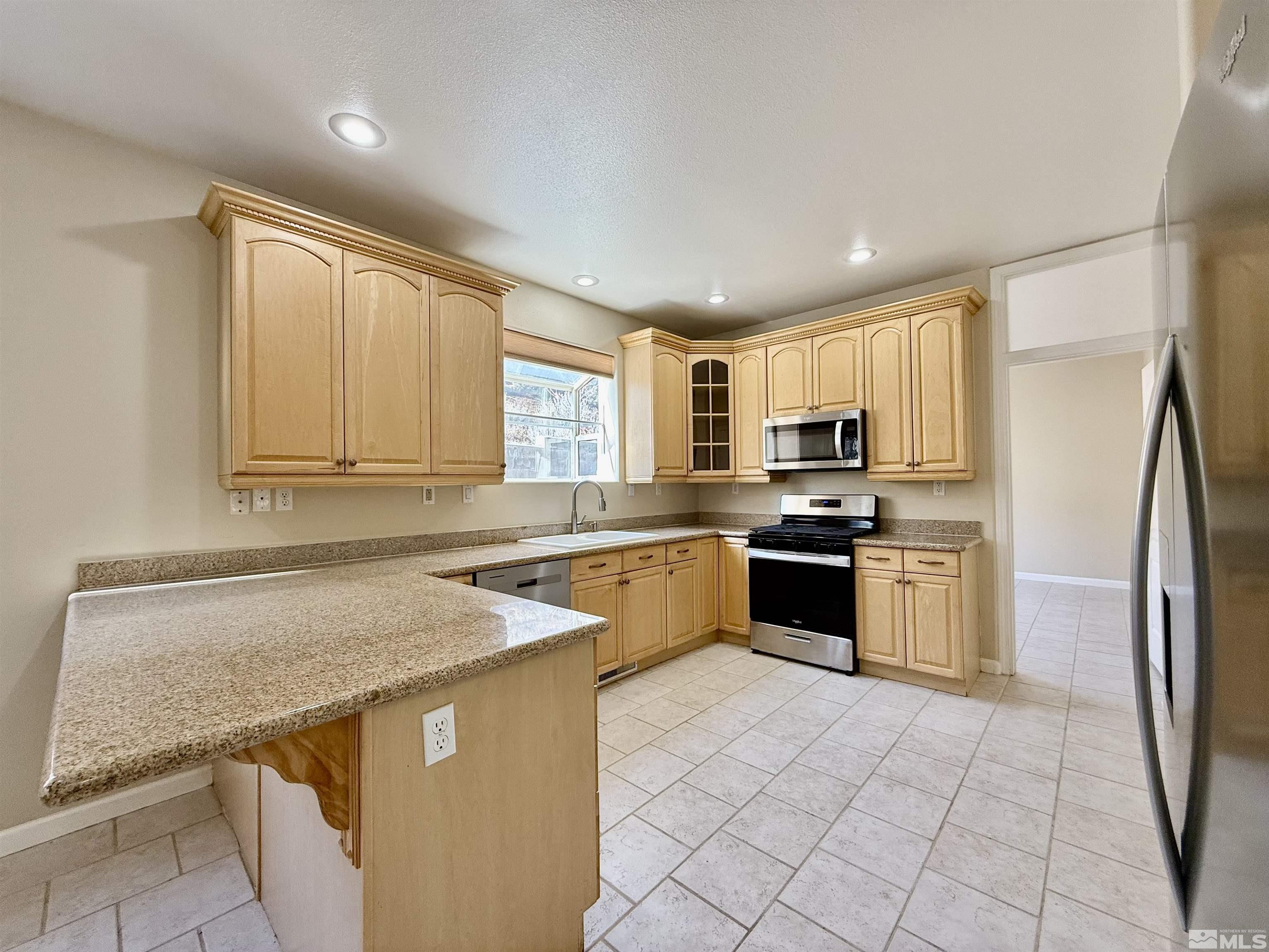 1090 Spring Drive Carson City, NV 89703 - Photo 9 of 31 a kitchen with stainless steel appliances granite countertop a stove a sink and a refrigerator