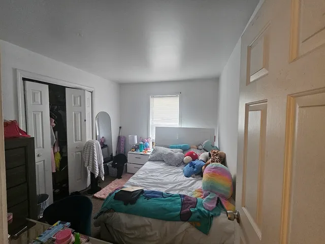 a bedroom with a bed closet and a mirror