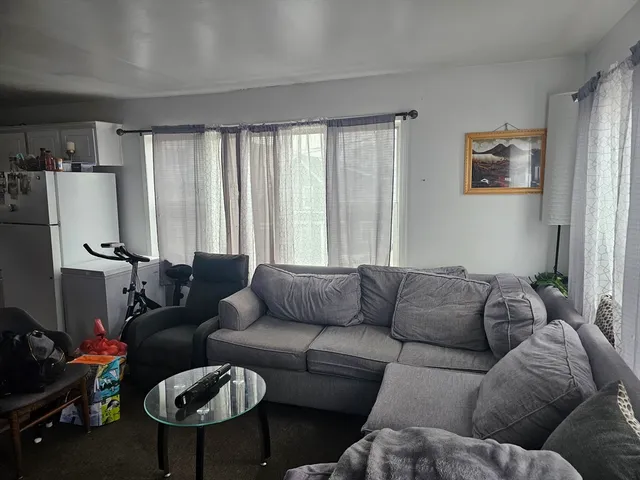 a living room with furniture ceiling fan and a window