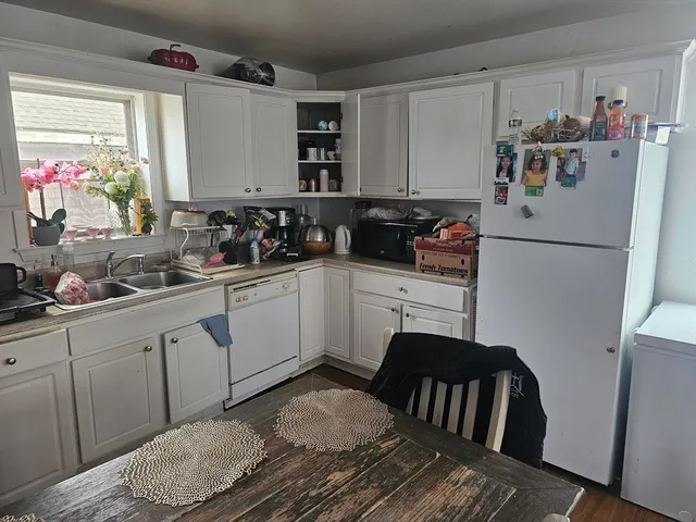 a kitchen with a sink refrigerator and cabinets
