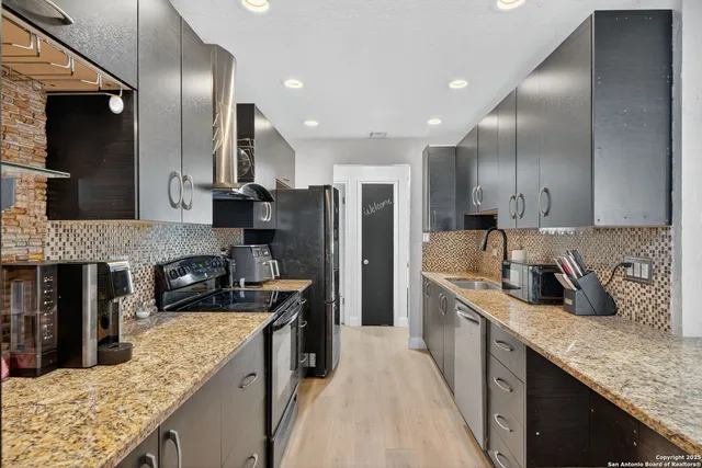 a kitchen with stainless steel appliances granite countertop a sink stove and refrigerator