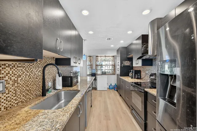 a large kitchen with stainless steel appliances kitchen island granite countertop a large counter top stainless steel appliances and cabinets