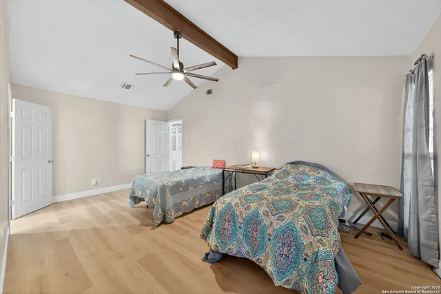 a bedroom with two beds and a chandelier