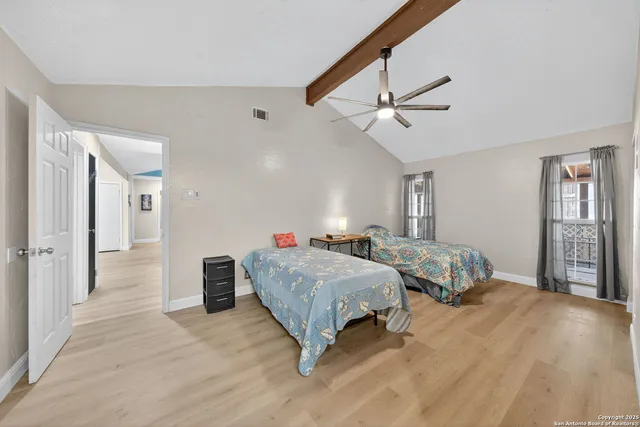 a spacious bedroom with a bed and ceiling fan