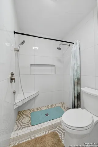 a bathroom with a toilet and a shower
