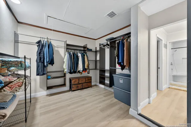 a view of walk in closet with clothes and shoes