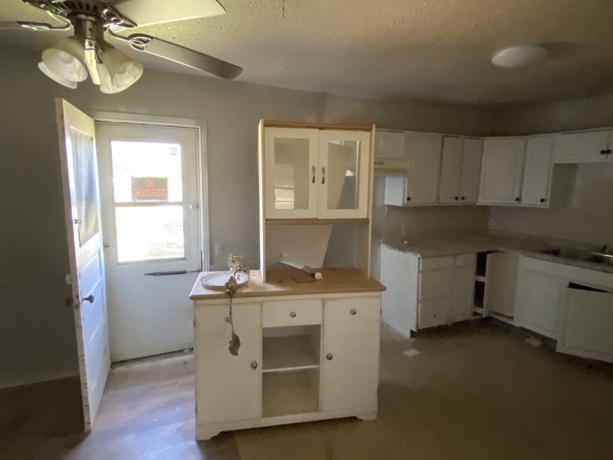 703 South Austin Avenue Tulia, TX 79088 - Photo 11 of 12 a kitchen with stainless steel appliances granite countertop a stove a sink and dishwasher with wooden floor