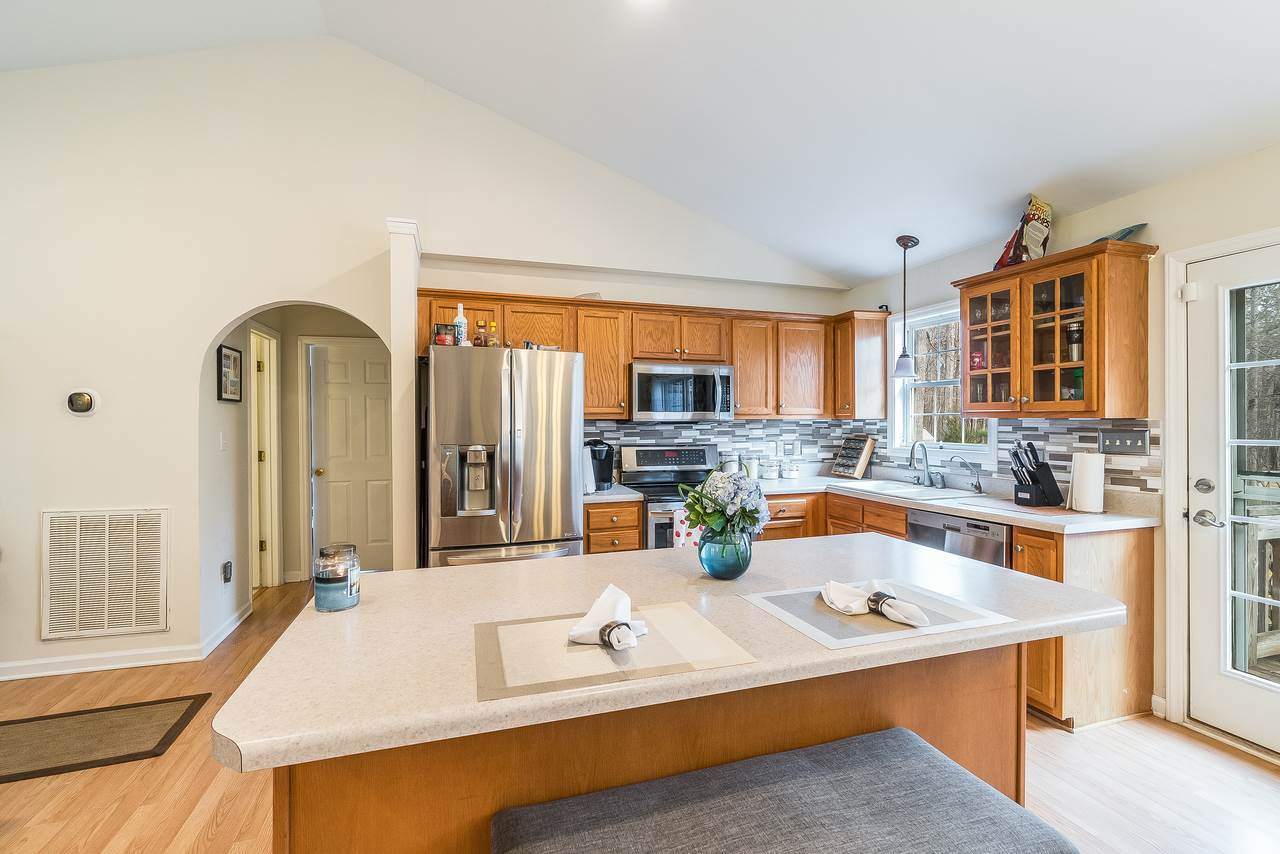 5712 Novaglen Road Durham, NC 27712 - Photo 9 of 27 Kitchen has beautiful tile backsplash & stainless steel appliances! Kitchen