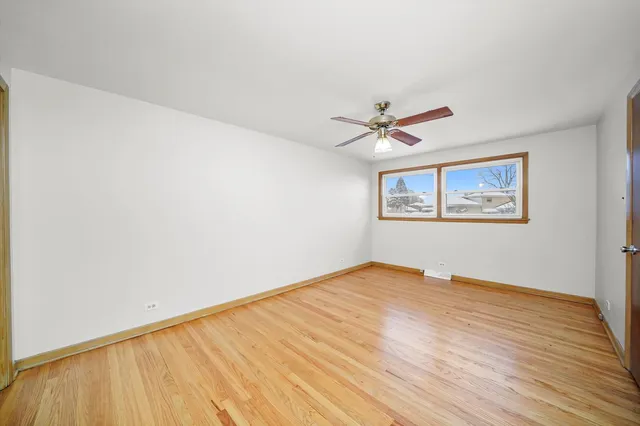 a view of a big room with wooden floor and a ceiling fan