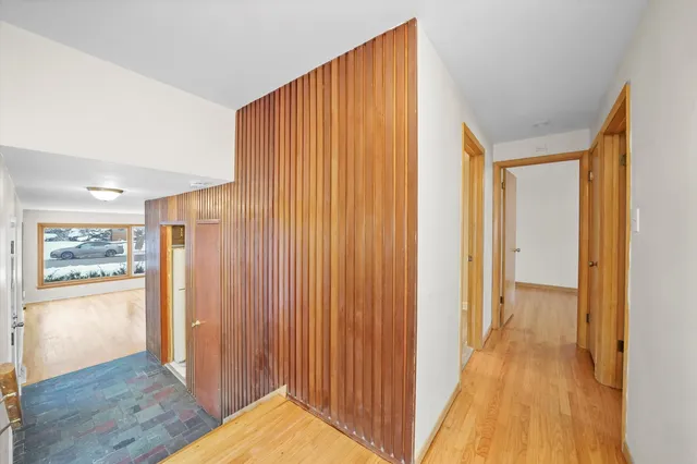 a view of a hallway with wooden floor and a cabinet