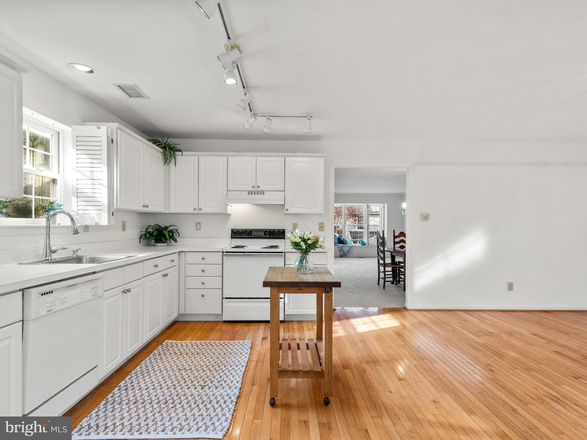 913 Harbour Ridge Lane Downingtown, PA 19335 - Photo 15 of 33 a kitchen with white cabinets and wooden floor