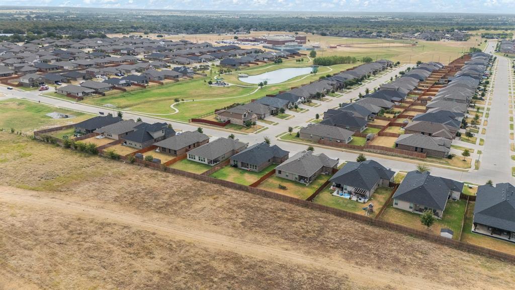 1812 Millbrae Road Cleburne, TX 76033 - Photo 26 of 30 Master-planned community with a central pond and green spaces, featuring uniform rooflines and a cohesive architectural style