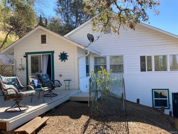 a view of a house with backyard and sitting area
