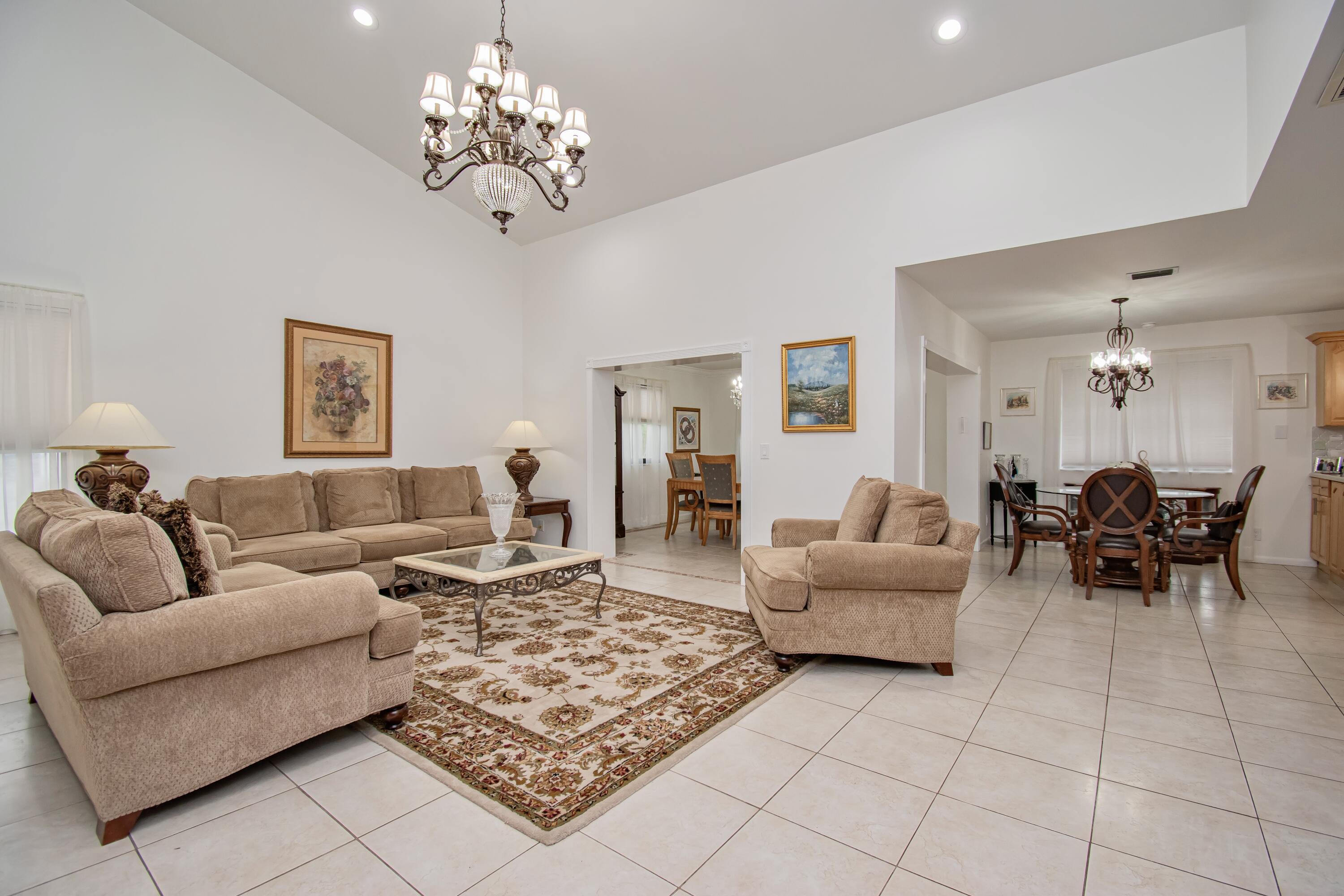 7838 Cypress Crescent Boca Raton, FL 33433 - Photo 6 of 24 a living room with furniture and a chandelier