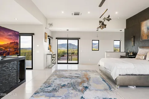 a spacious bedroom with a large bed a flat screen tv and a fireplace
