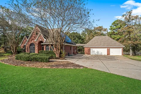 a front view of a house with a garden and trees