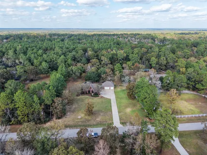 an aerial view of a houses with outdoor space and trees