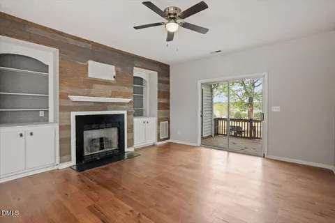 a view of an empty room with a fireplace and a window